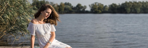 Portrait of a young beautiful girl in reeds in retro style in a light dress