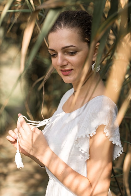 Portrait of a young beautiful girl in reeds in retro style in a light dress.