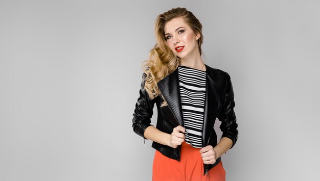 Portrait of a young beautiful girl with blond hair in a leather jacket