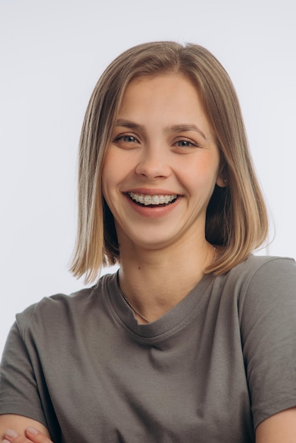 Photo portrait of a young beautiful girl with braces on a white background