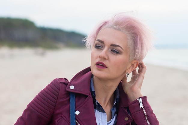 Foto ritratto di una giovane bella ragazza con i capelli rosa sul mare