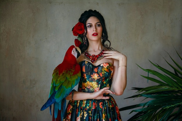 Portrait of a young beautiful girl with a red macaw