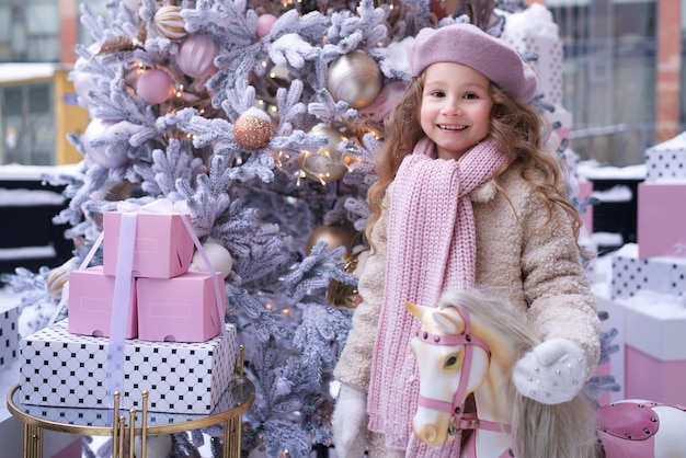 Portrait of young beautiful kid child girl in christmas decoration at winter snowy day near