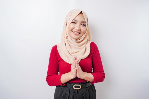 Portrait of a young beautiful Muslim woman wearing a hijab gesturing Eid Mubarak greeting