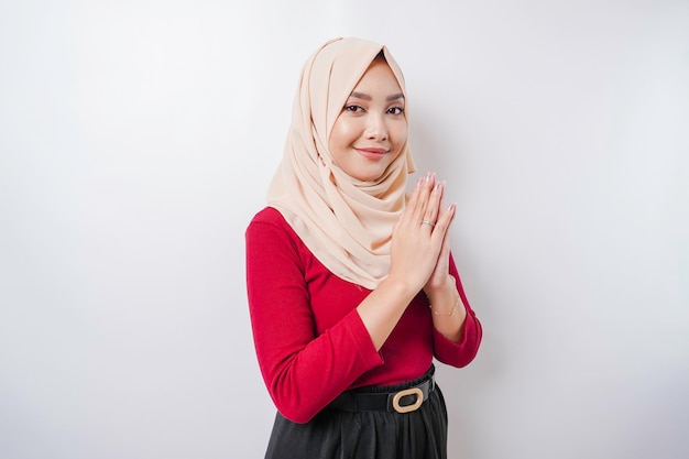 Portrait of a young beautiful Muslim woman wearing a hijab gesturing Eid Mubarak greeting