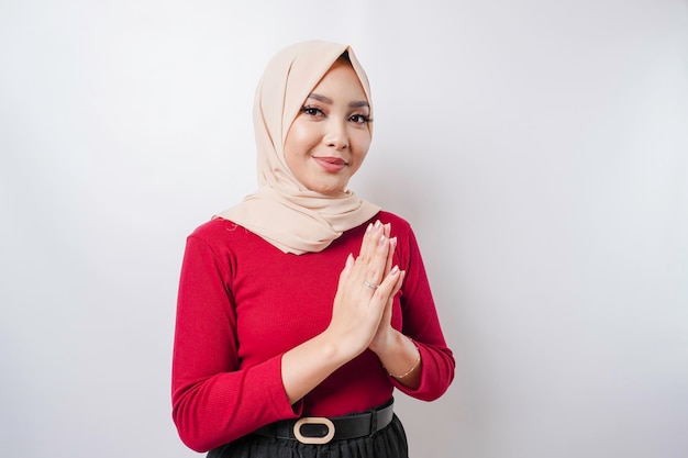 Portrait of a young beautiful Muslim woman wearing a hijab gesturing Eid Mubarak greeting