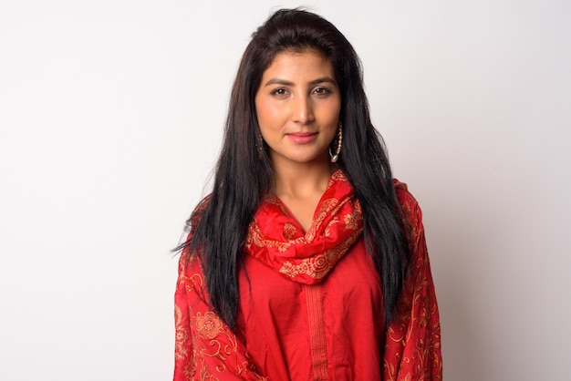 Portrait of young beautiful Persian woman wearing traditional clothing against white wall