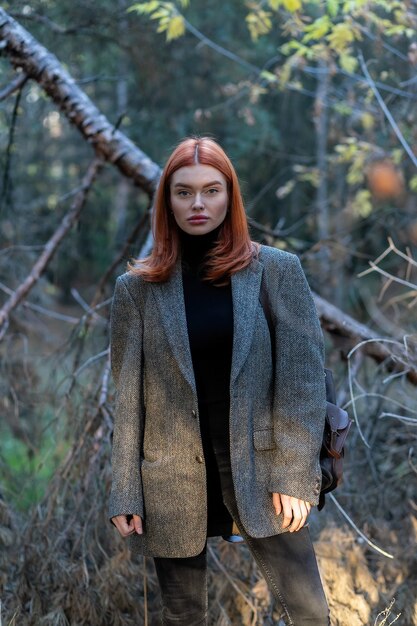 Portrait of a young beautiful red haired woman, outside. A good dark day with beautiful shadows a sunny day, sunset. Self isolation in the open air.