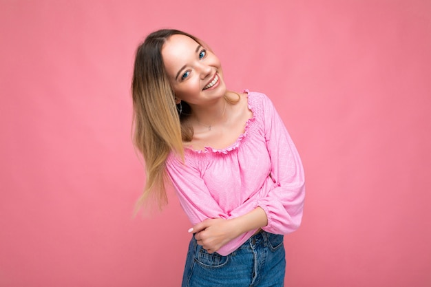 Portrait of young beautiful smiling hipster blonde woman in trendy pink crop top blouse sexy