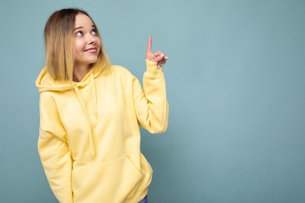 Portrait of young beautiful smiling hipster blonde woman in trendy yellow hoodie sexy carefree