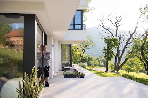 portrait of a young beautiful successful woman in the doorway of her luxury home villa