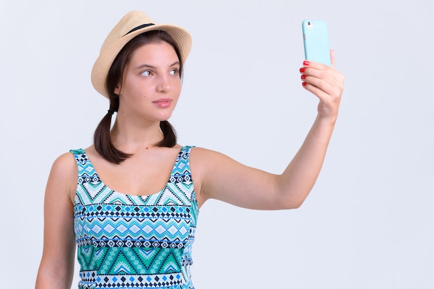 Portrait of young beautiful tourist woman on white