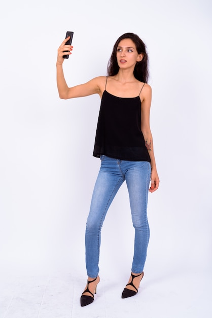 Portrait of young beautiful woman against white wall