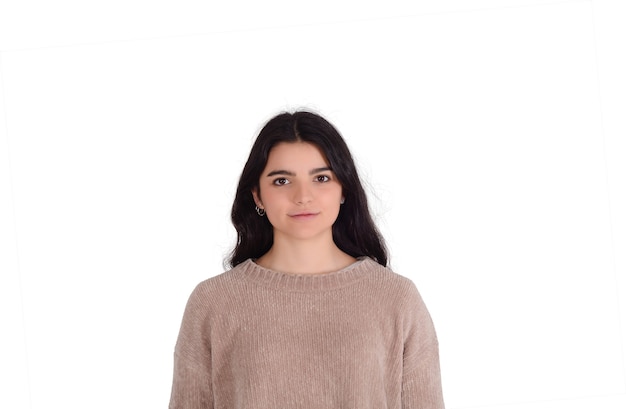 Portrait of young beautiful woman against white wall.