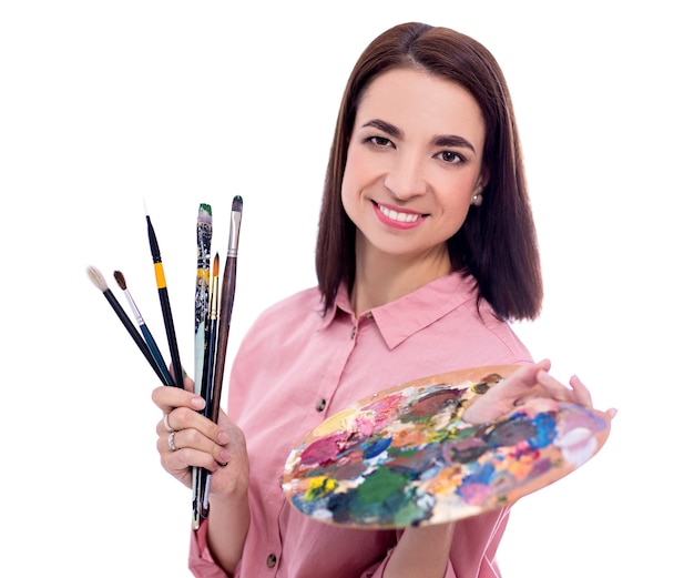 Portrait of young beautiful woman artist with palette and paint brush isolated on white background