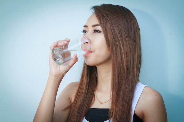 夏の若い美しい女性のアジアの飲料水の肖像画とボトル