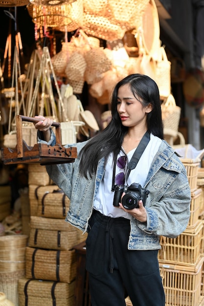 Portrait of young beautiful woman buying local product while traveling at the local market