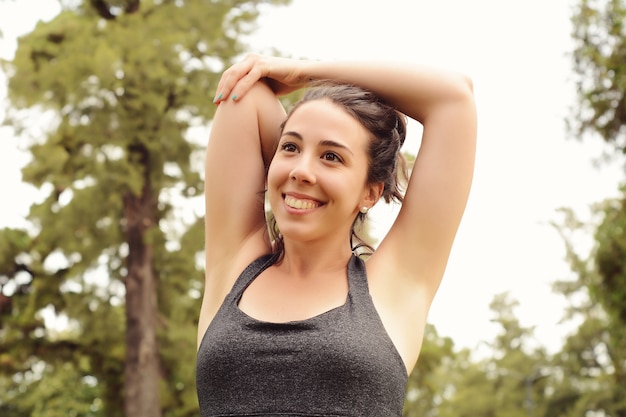 Portrait of young beautiful woman doing exercise at park