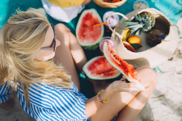 Photo portrait of young beautiful woman eating watermelon
