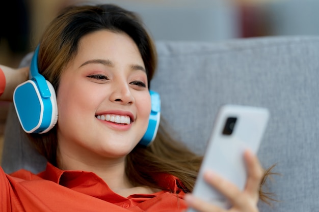 Portrait of young beautiful woman enjoying the music with smiley face sitting in creative office or cafe