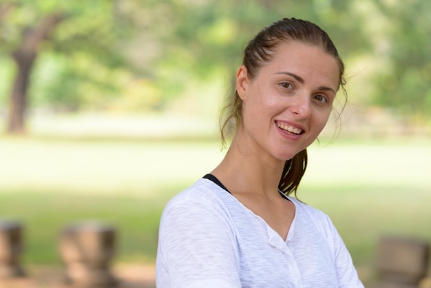 Portrait of young beautiful woman exercising at the park outdoors