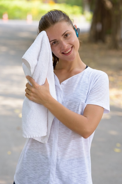 Photo portrait of young beautiful woman exercising at the park outdoors