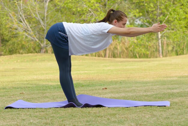 屋外の公園で運動している若い美しい女性の肖像画