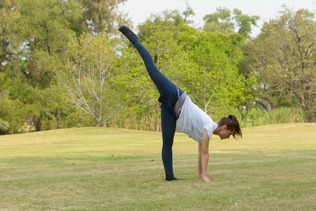 屋外の公園で運動している若い美しい女性の肖像画