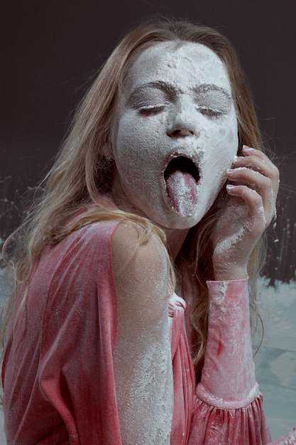 Portrait of a young beautiful woman in flour Woman showing tongue