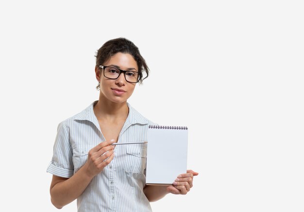 Portrait of a young beautiful woman in glasses with a pencil and a notepad