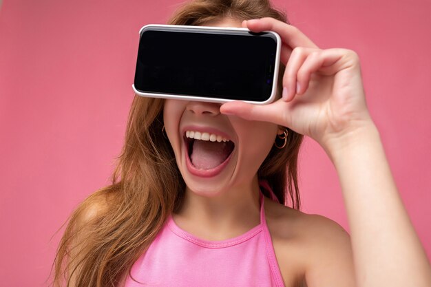 Portrait of young beautiful woman holding smartphone