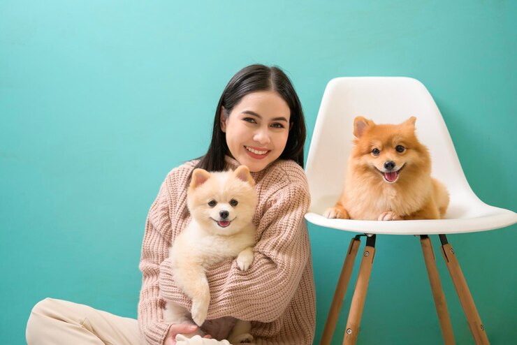 Photo 젊은 아름다운 여성의 초상화는 녹색 배경 위에 그녀의 개에게 키스하고 안아줍니다