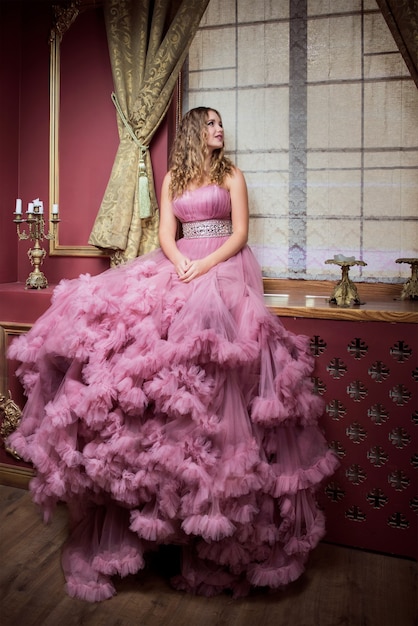 Photo portrait of young beautiful woman in long pink dress