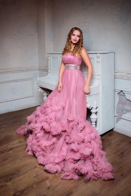 portrait of young beautiful woman in long pink dress