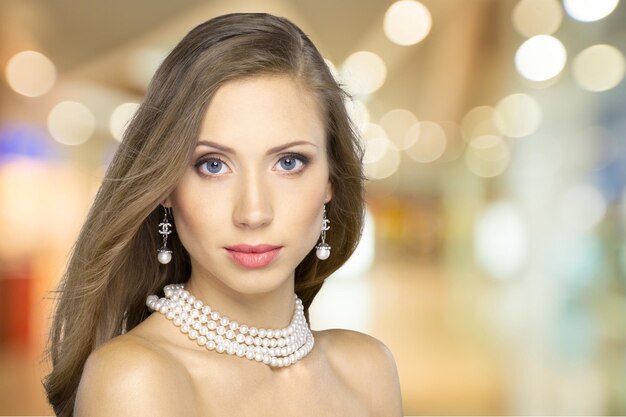 Photo portrait of young beautiful woman in necklace