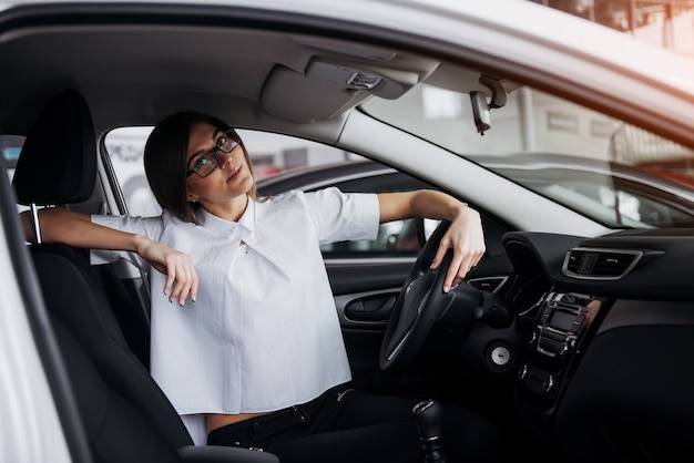 車の中で座っている若い美しい女性の肖像画