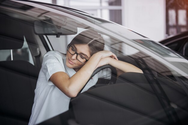 車の中で座っている若い美しい女性の肖像画