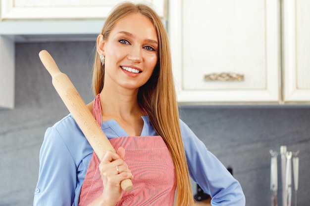 Portrait of a young beautiful woman standing in a kitchen