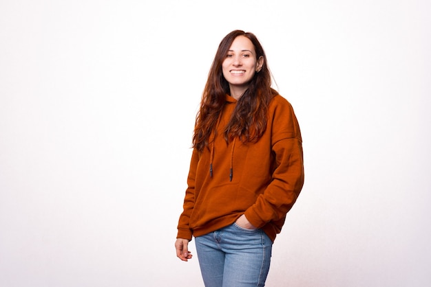 portrait of a young beautiful woman standing with  a hand in her pocket and smiling at the camera