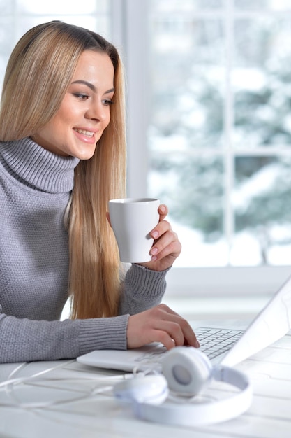 Portrait of young beautiful woman using laptop