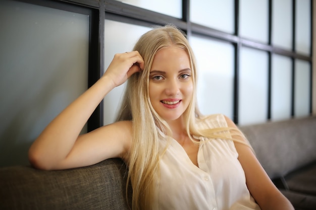 Foto ritratto di una giovane bella donna con i capelli biondi che sorride alla telecamera