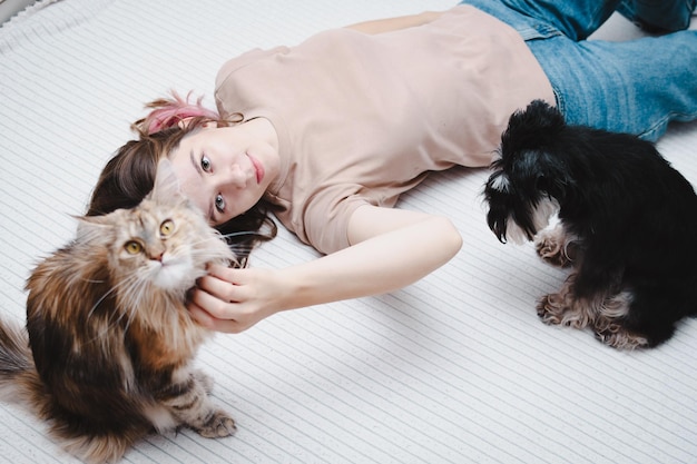 猫と犬を一緒に持つ若い美しい女性の肖像画