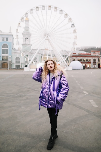 Portrait of young beautiful woman with curly blondie hair outdoors. Beauty, fashion concept. Street style. Bokeh background