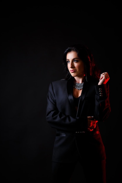 Portrait of a young beautiful woman with dark hair of European appearance Dressed in a black jacket Isolated on black background