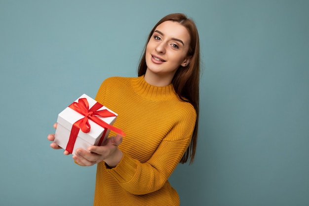 Portrait of young beautiful woman with gift box