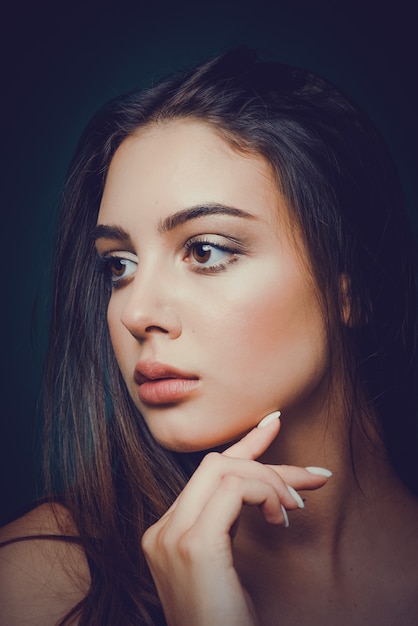 Portrait of a young and beautiful woman with her hand near face