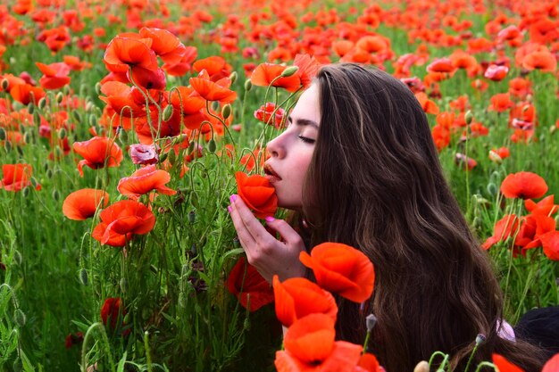 Portrait of young beautiful woman with red poppies