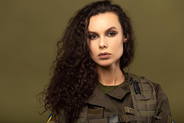 Portrait of young beautiful woman with serious expression on\
the face of military soldier