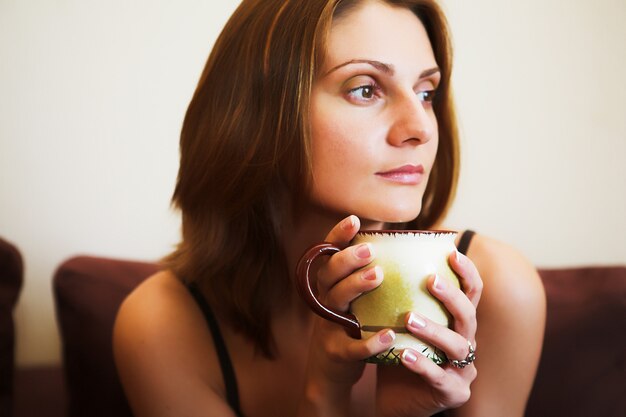 Portrait of young beautiful woman with tea