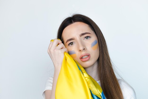 Portrait of young beautiful woman with Ukrainian flag stand on white backgroung Stop war in Ukraine